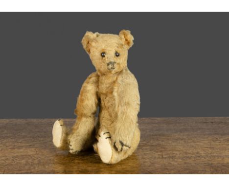 A small early Steiff teddy bear, with apricot mohair, black boot button eyes, pronounced clipped muzzle, black stitched nose,