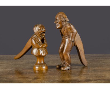 A French carved wooden elderly couple nutcrackers, the man a full figure with hands in his pockets with lever action —8in. (2