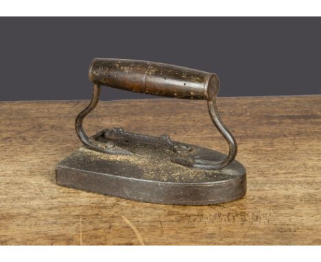 An iron box iron,  possibly French, with turned wooden handle and gate catch on top of iron —5¾in. (14.5cm.) long (hook missi