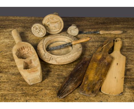 Wooden butter tools, three butter paddles; three butter moulds, one carved with a ewe and the others with cows —5½in. (14cm.)