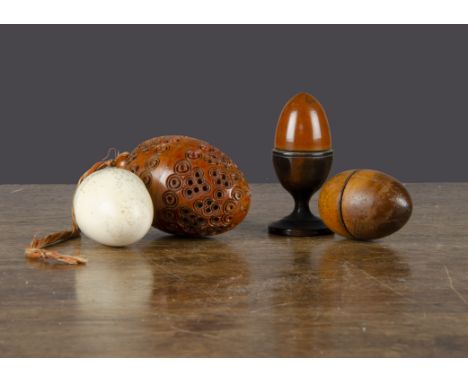 Treen eggs, a turned wood nutmeg grater —2in. (5cm.) high (glue repairs to top half); an egg in egg cup opening to reveal ano