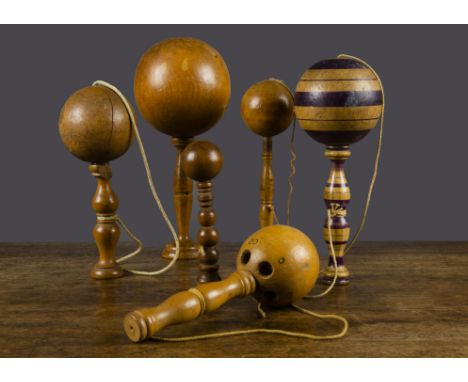 Six turned wood cup and ball games, including a fine 19th Century example with turned stick —7½in. (19cm.) high; another with