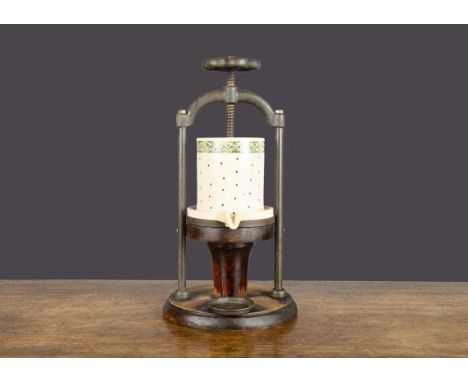 A late 19th Century fruit juicer, cast-iron frame with pottery fruit holder decorated with a grapevine border, screw action s