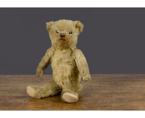 A small 1930s Chiltern teddy bear, with golden mohair, clear and black glass eyes, pronounced clipped muzzle, black stitched 