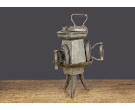 A small cast-iron portable laundry stove,  on tripod feet with three small flat irons —8¼in. (21cm.) high (missing chimney an