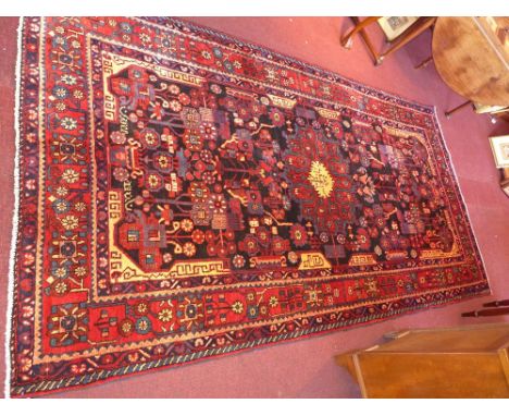 A fine North West Persian Nahawand carpet 307cm x 165cm double pendant medallion with petal motifs on a midnight field within