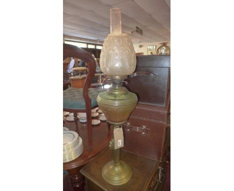 A Victorian brass oil lamp, having a frosted glass shade decorated with Acanthus leaves, and a yellow reservoir 