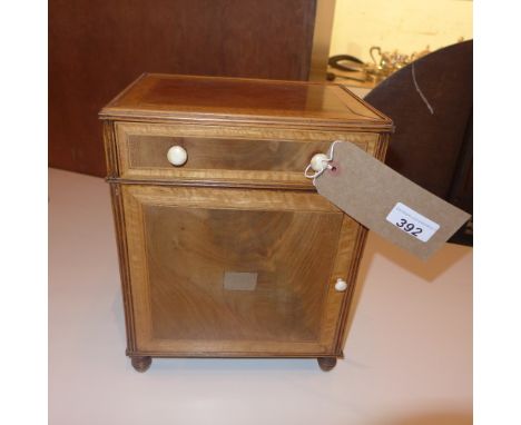 A Georgian octagonal form marquetry inlaid tea caddy decorated with swags and floral reserves