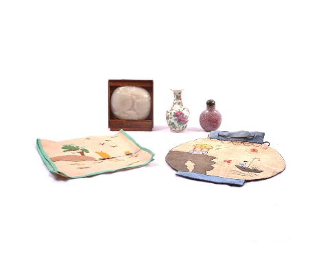 Small carved jade disc, oval form and slightly dished, carved with pomegranate fruits, held in a wooden stand, disc 7.5cm x 7