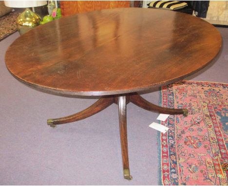 BREAKFAST TABLE, George III mahogany with an oval tilt top on a turned pedestal column with swept feet having brass cappings 