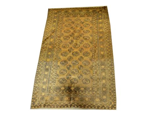 Bokhara rug, gold-coloured ground, three rows of nine guls, multi-bordered, 198 x 97cm; a Hamadan rug, large stepped floral m