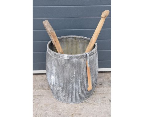 A vintage galvanised dolly tub, 52cm tall, together with accessories to include wash board, wooden posser and a pair of grabs