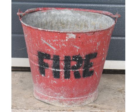 Vintage metal fire bucket with swing-over handle painted red with 'FIRE' in black, 30cm tall with handle down.  