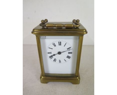 A brass carriage clock - Height 12cm - chip to top of dial - working