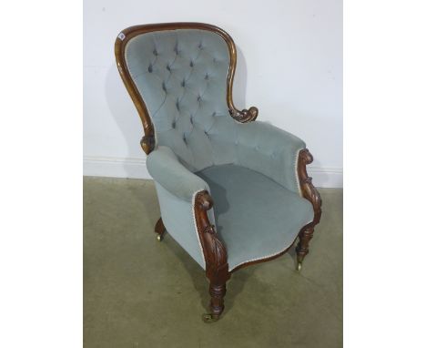 A blue velour upholstered button back mahogany framed open armchair circa 19th century, carved frame, raised on turned suppor