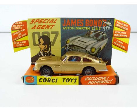 A CORGI 261 James Bond's Aston Martin in gold with working bullet shield, guns and ejector seat - bandit in car and spare ban