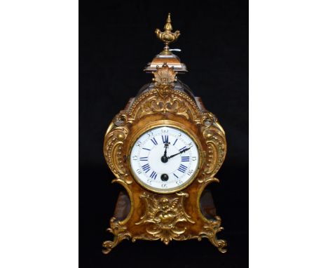 A CONTINENTAL ROCOCO STYLE MANTLE CLOCK  the walnut case with gilt metal mounts with masks and scrollwork, the enamel dial wi