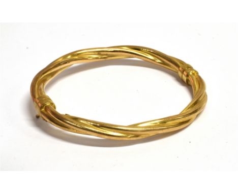 A 9CT GOLD HINGED BANGLE  the barley twist design of hollow construction with sprung clasp, weighing approx. 10.3 grams Condi