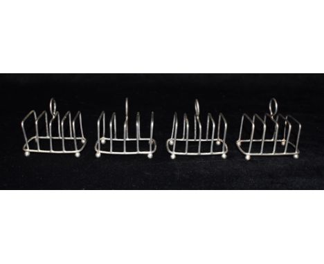 A1213 - 29  A SET OF FOUR SMALL SILVER TOAST RACKS  By Heseler Brothers, The wirework, 4 slice toast racks on ball feet, Hall