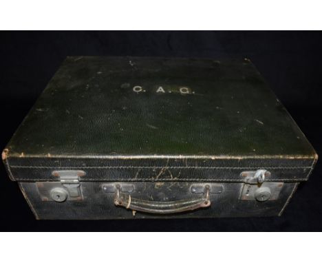 A GENTLEMAN'S LEATHER TRAVELLING DRESSING CASE  the green leather case with a fitted interior, containing a part set of glass
