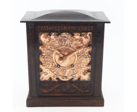 An Arts and Crafts oak and copper mantle clock, the cuboid case with shallow domed pediment top supported on tapered and spla