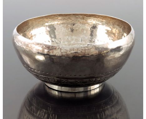 Hugh Wallis, an Arts and Crafts silver bowl, Chester 1916, planished and footed with inverted rim, incised and hammered with 