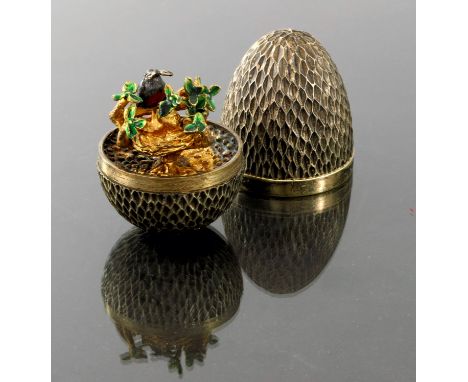 Stuart Devlin, a Modernist silver gilt and enamelled novelty surprise egg, London 1976, rusticated body with plain band, open