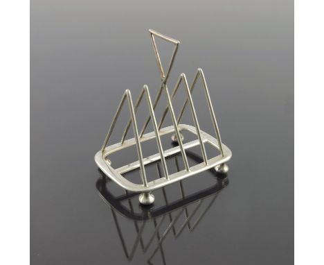 A Victorian silver four division toast rack, Henry Wilkinson and Co., London 1892, in the style of Christopher Dresser, trian