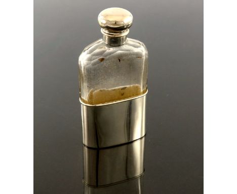 A Continental silver and glass spirit flask, circa 1920s, the oval section faceted bottle with bayonet cap and removable beak