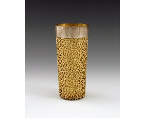 Stuart Devlin, a Modernist silver and parcel gilt beaker, London1973, tall cylindrical form, overlaid with a cast rusticated 