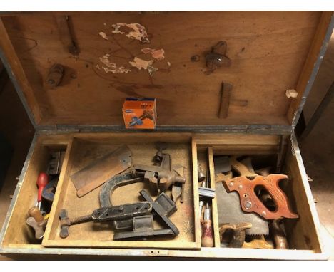 Wooden chest containing various woodworking tools including saws, clamps, hammers etc