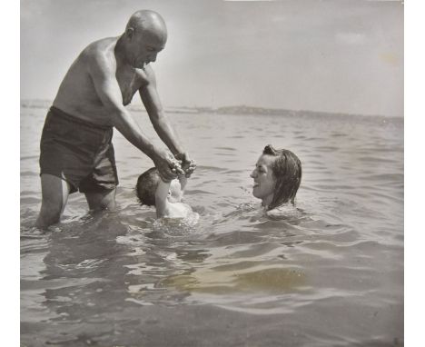 *Capa (Robert, 1913-1954). Pablo Picasso and Francoise teaching their baby Claude to swim, c. 1950, printed later,  gelatin s