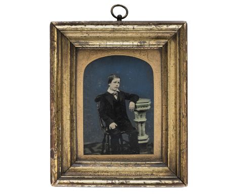 *Quarter-plate ambrotype of a seated boy against a blue background, 1860s,  gilden wooden frame with chased brass mat and hig