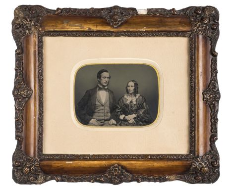 *Half-plate ambrotype of a newly married couple, 1850s,  tinted, 11 x 15cm, cream mat, decorative wooden plaster frame, overa