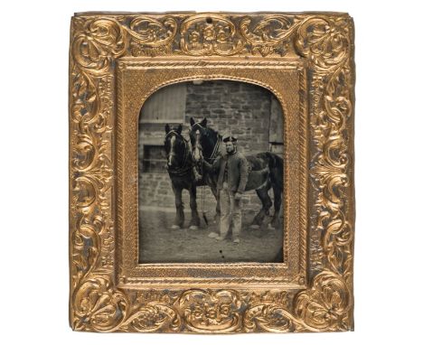 *Sixth-plate ambrotype of a stable-hand and two horses outdoors, 1860s,  in French pressed metal wall frame, overall 12 x 11c