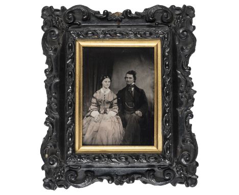 *Half-plate ambrotype of a husband and wife, 1850s,  tinted, 13 x 9.5cm, wood and plaster frame with gilt surround, overall 2