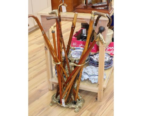 A group of walking sticks and canes, including a sword stick c.1900 and a Chinese silver topped cane, with a brass stick stan
