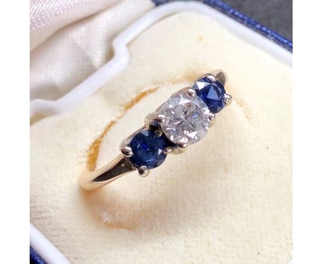 Diamond and sapphire ring set with cental diamond that measures approx 5.5mm dia with two sapphires ring shank split 
