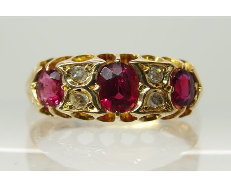 An 18ct gold ruby and rose cut diamond ring in scalloped setting with engraved shoulders, finger size P1/2. Weight 3.8gms