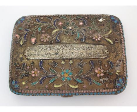 A Middle-Eastern white-metal and enamel cigarette case with hinged body of filigree design, with band of Arabic text, 10cm wi