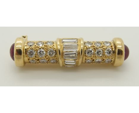 A bright yellow metal diamond and ruby brooch of baton shape set with brilliant cut and baguette diamonds. With oval caboucho