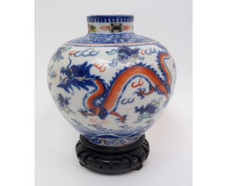 A Chinese Wucai globular vase painted with dragons and precious objects amongst clouds beneath a foliate scroll band, Yongzhe