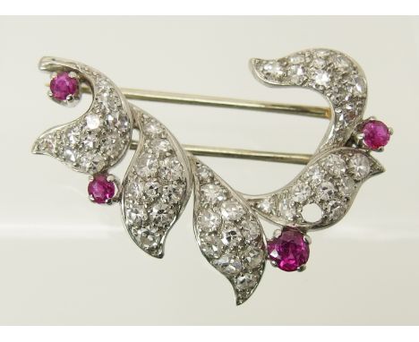 A diamond and ruby brooch set throughout in white metal. length 3.1cm x 2.3cm, weight 5.8gms