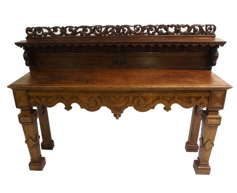 A Victorian oak hall table the pierced foliate rail above a shelf supported by griffins, lion mask and cherub bracket, the re