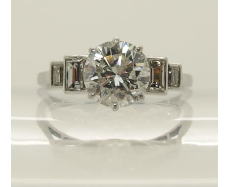 A platinum and diamond Art Deco ring the central diamond of estimated approx 1.24cts with four further baguette diamonds to t