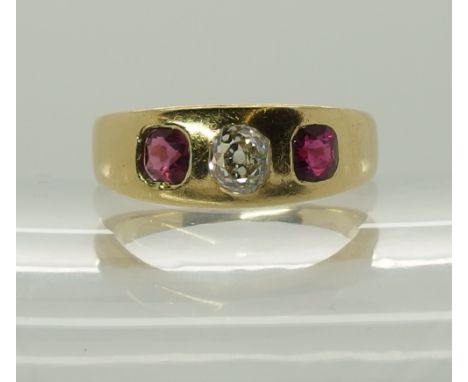 A bright yellow metal band ring set with an old cut diamond diamond estimated approx 0.48cts, red gems do not match, one a ru