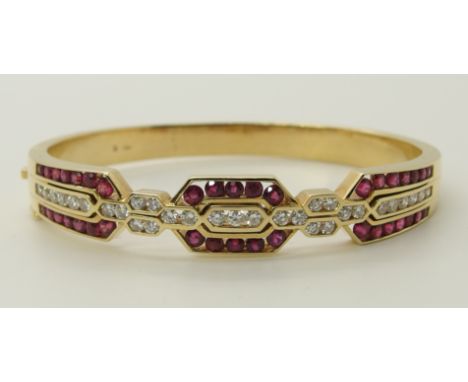 An 18ct gold ruby and diamond bangle estimated approx diamond content 1.40cts, internal diameter 4.7cm x 5.8cm, weight 43.2gm