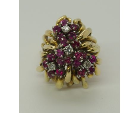 A bright yellow metal ruby and diamond retro cluster ring the rubies and diamonds are set as flowers with free form leaf desi