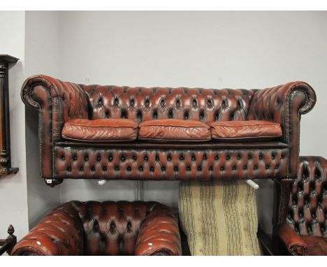 A XX Century Ox Blood Leather Three Seater Chesterfield Settee, on bun feet, 195cm wide.