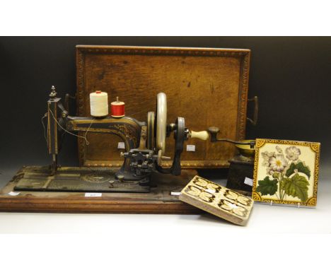 A Kenrick and Sons coffee grinder; a Singer sewing machine; a Victorian tile, another; an early 20th century oak twin handled